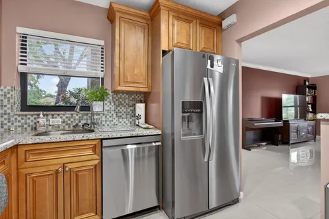 a kitchen with stainless steel appliances granite countertop a refrigerator and a sink