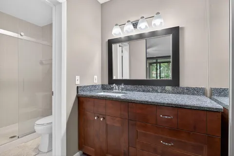 a bathroom with a granite countertop sink and a mirror