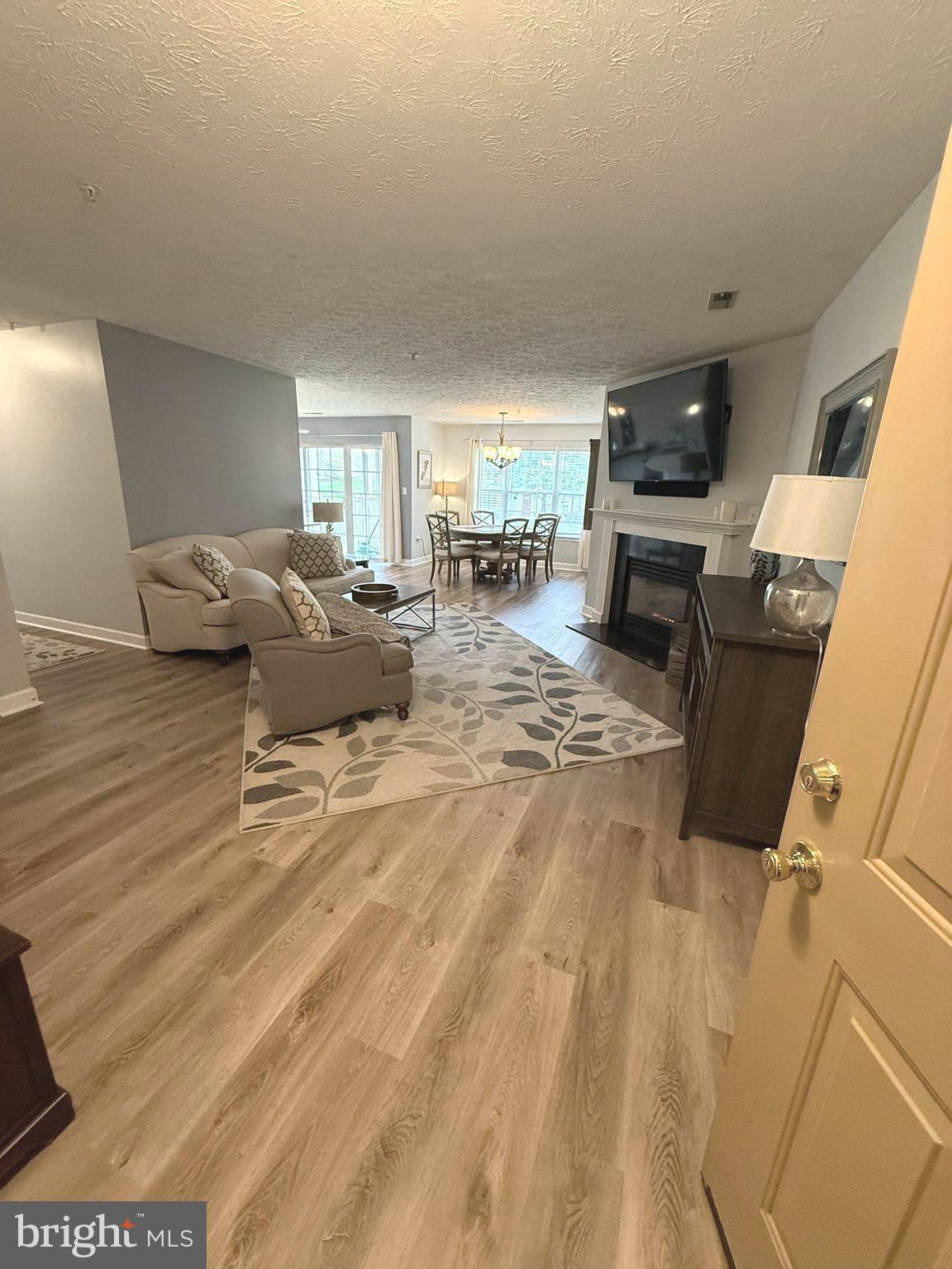 6343 Springwater Terrace, Unit 1012 Frederick, MD 21701 - Photo 2 of 39 a living room with furniture and a flat screen tv