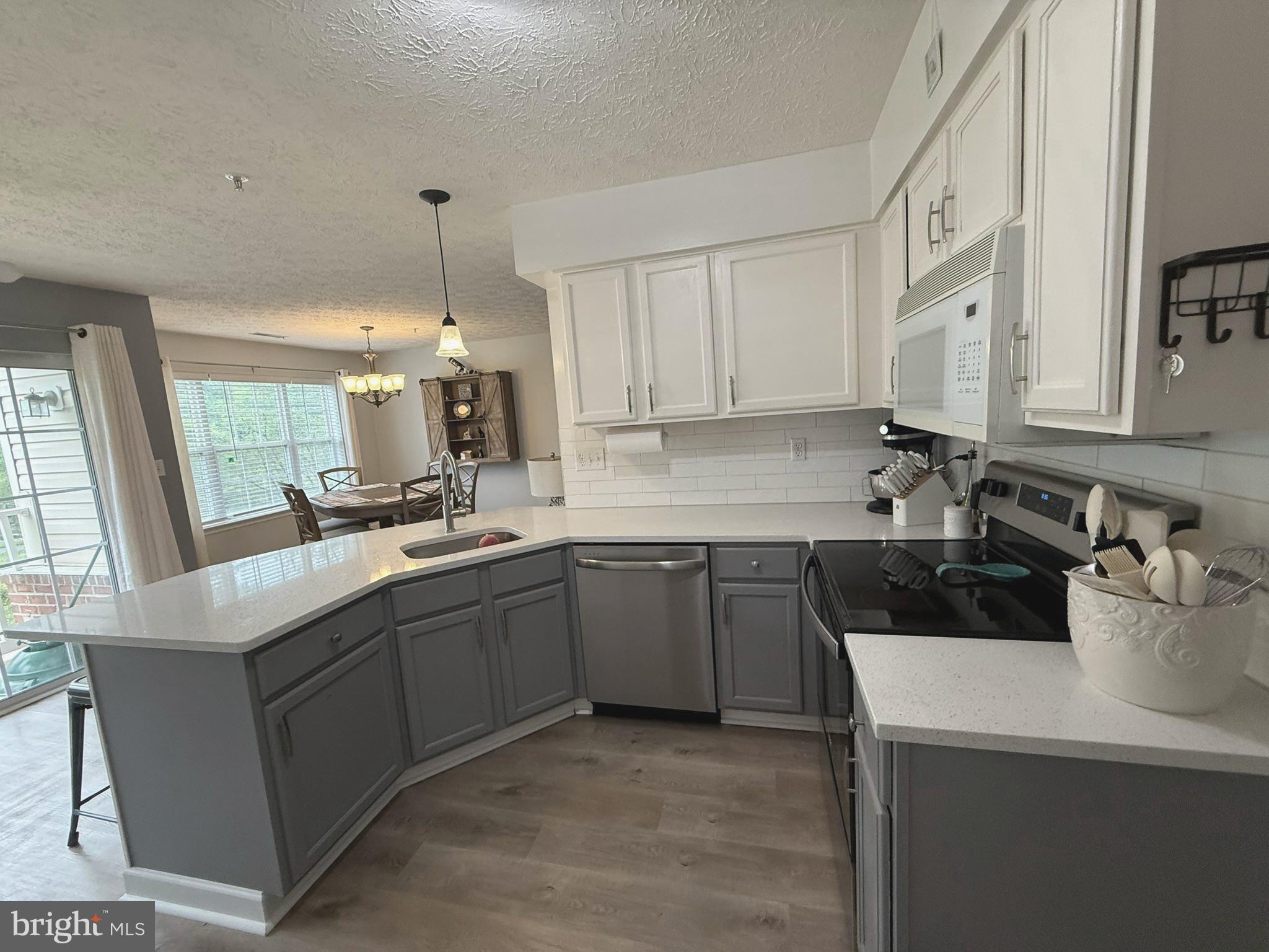 6343 Springwater Terrace, Unit 1012 Frederick, MD 21701 - Photo 21 of 39 a kitchen with a sink stove and cabinets