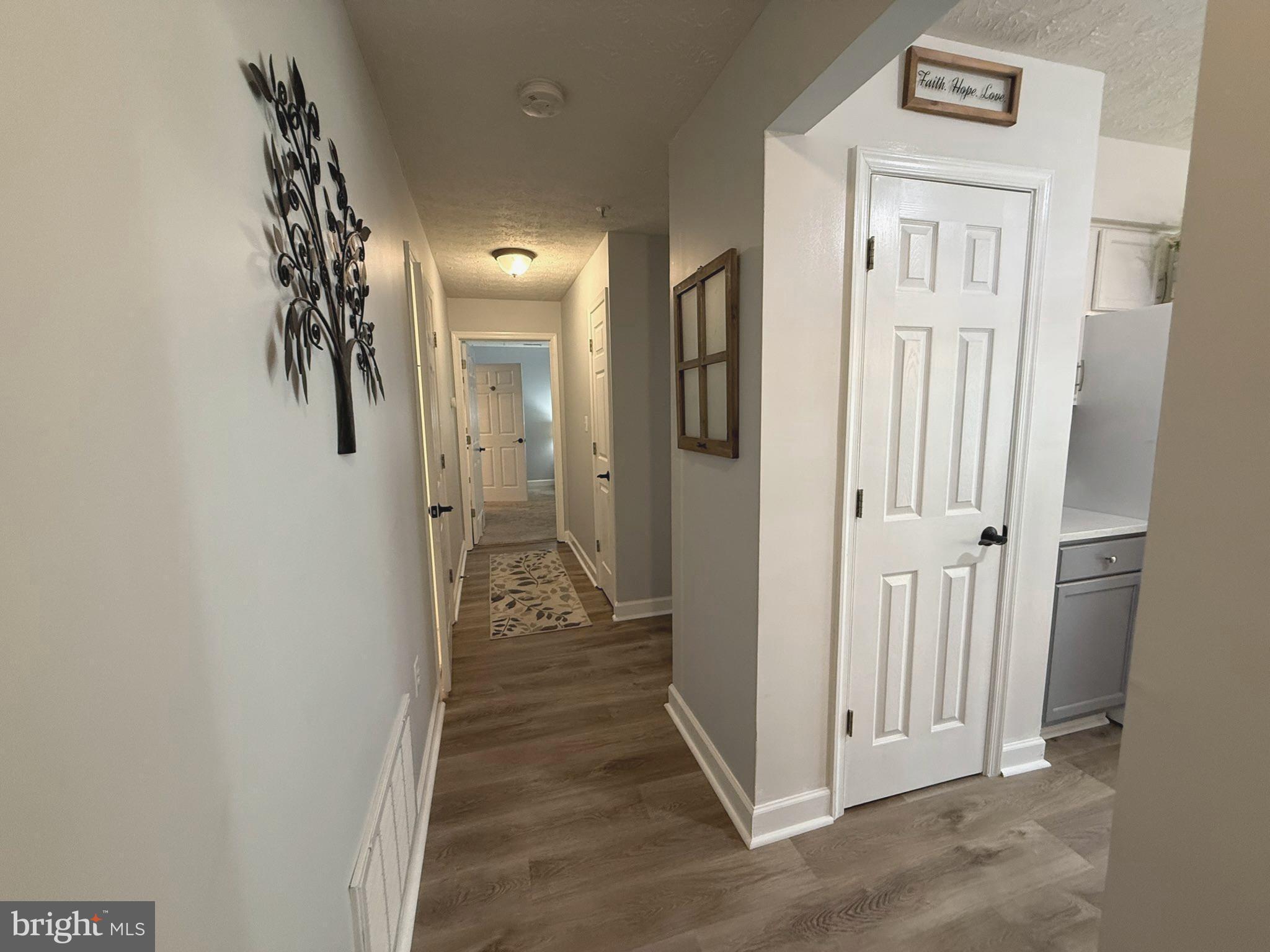 6343 Springwater Terrace, Unit 1012 Frederick, MD 21701 - Photo 23 of 39 a view of a hallway with wooden floor
