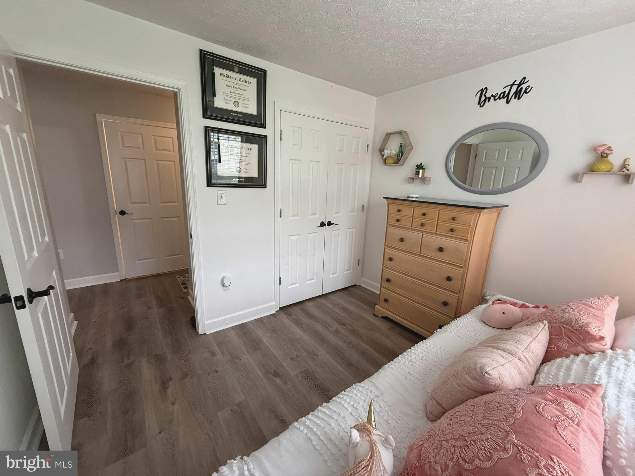 6343 Springwater Terrace, Unit 1012 Frederick, MD 21701 - Photo 27 of 39 a bedroom with a bed and a dresser in it
