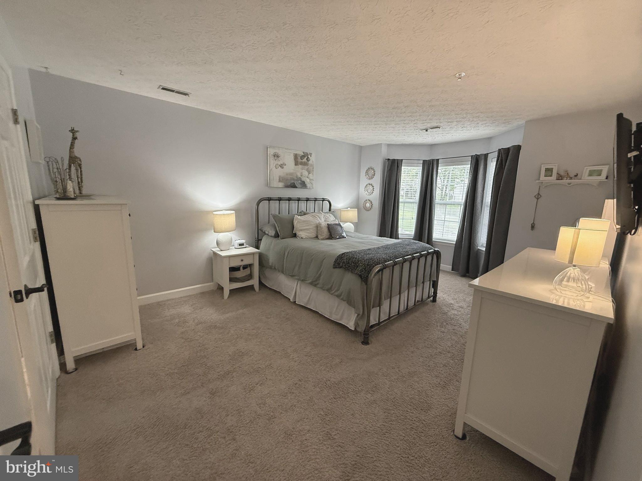 6343 Springwater Terrace, Unit 1012 Frederick, MD 21701 - Photo 30 of 39 a living room with a bed furniture and a refrigerator