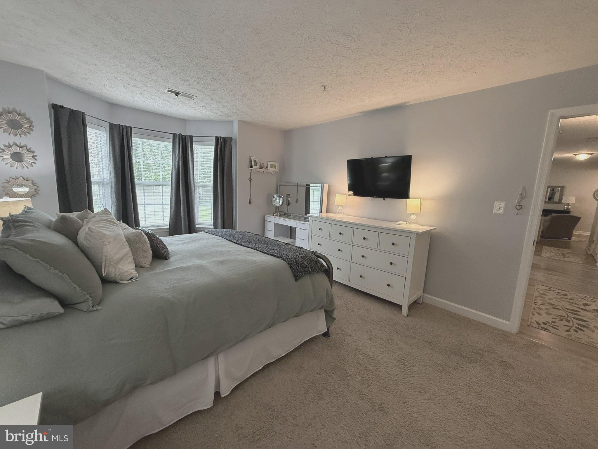 6343 Springwater Terrace, Unit 1012 Frederick, MD 21701 - Photo 32 of 39 a bedroom with a bed and a flat screen tv