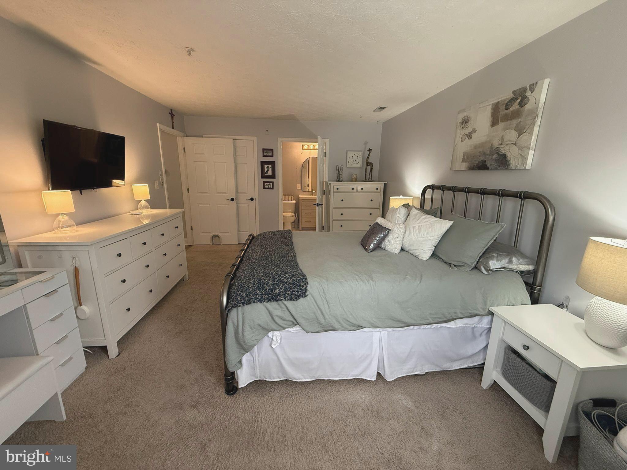 6343 Springwater Terrace, Unit 1012 Frederick, MD 21701 - Photo 33 of 39 a spacious bedroom with a bed and flat screen tv