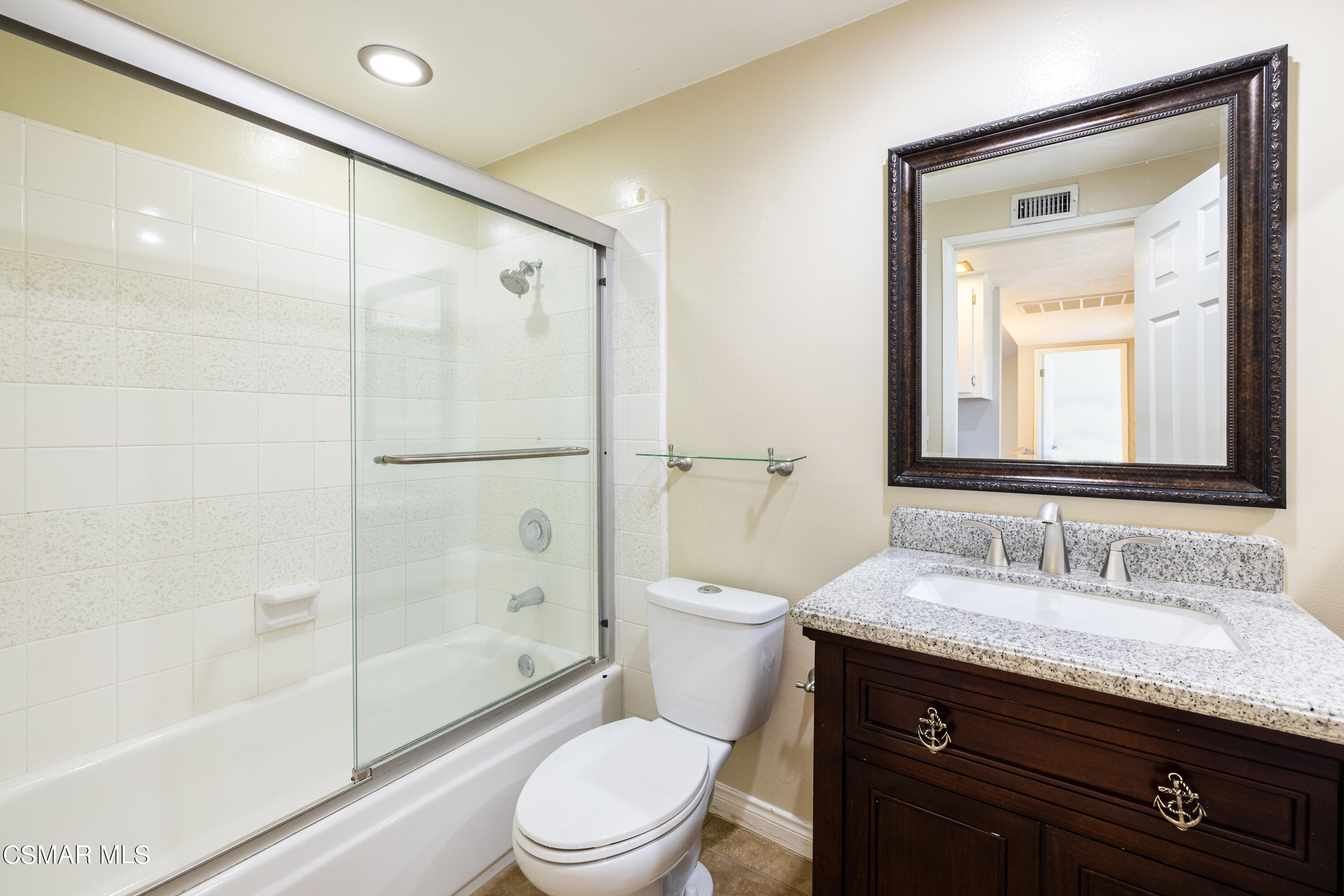 2456 Victoria Street Simi Valley, CA 93065 - Photo 19 of 24 a bathroom with a granite countertop sink toilet a mirror and shower