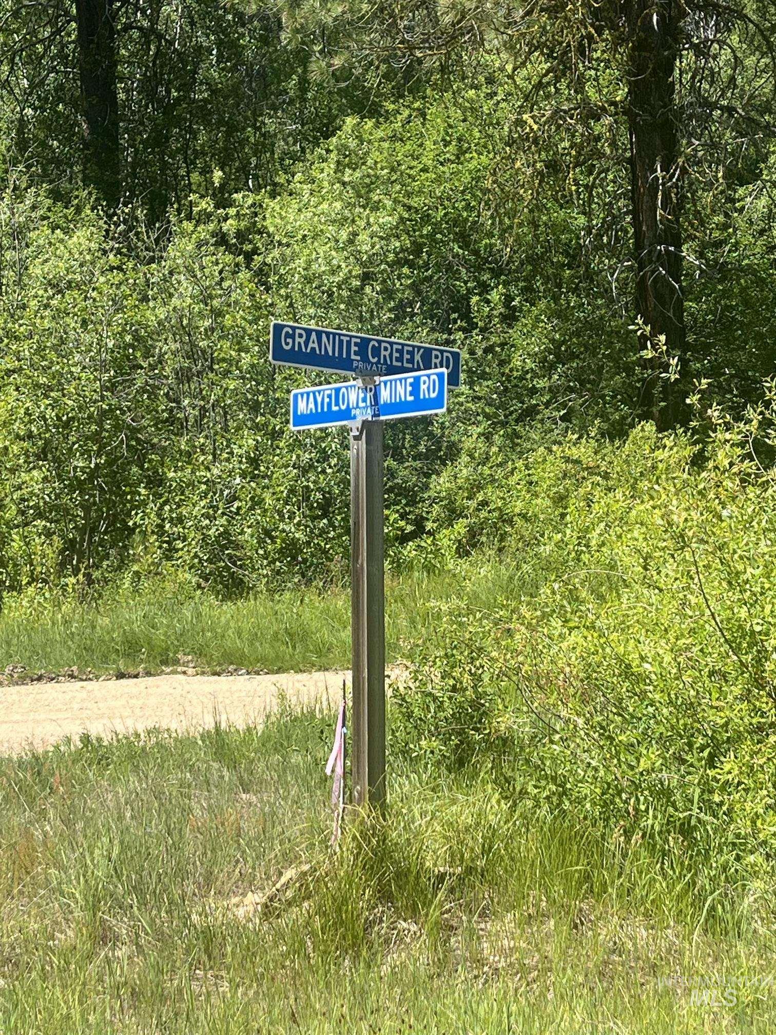 39 Mayflower Mine Road Placerville, ID 83666 - Photo 12 of 36 Street signpost marking the intersection of Granite Creek Road and Mayflower Mine Road, surrounded by lush green foliage and mature trees