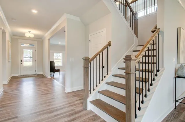 a view of staircase with wooden floor and white walls