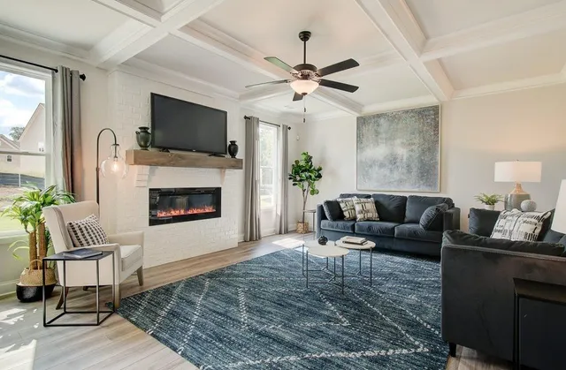 a living room with furniture a flat screen tv and a fireplace