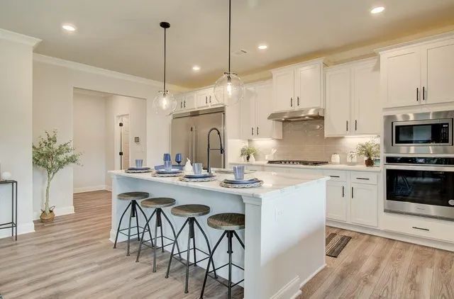 a kitchen with appliances cabinets and wooden floor