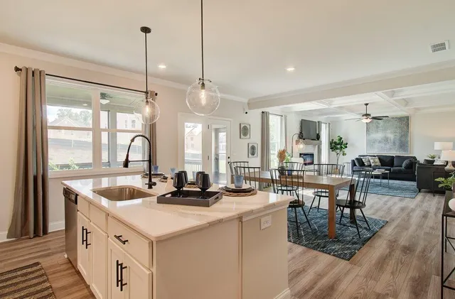 a kitchen with stainless steel appliances granite countertop a sink a counter top space and living room view