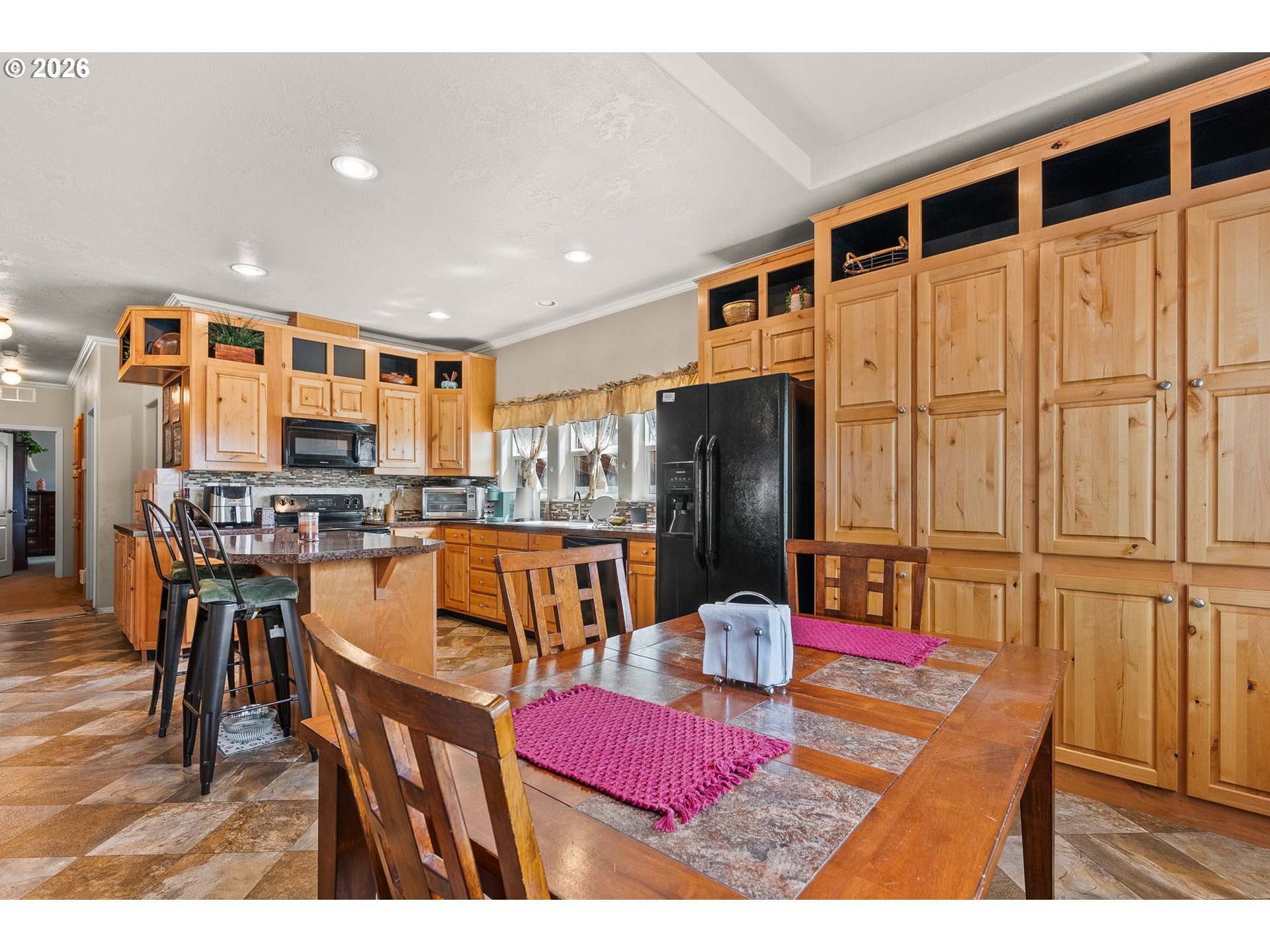 13620 Southwest Beef Bend Road, Unit 1 Portland, OR 97224 - Photo 12 of 34 a kitchen with stainless steel appliances kitchen island granite countertop a refrigerator a stove a sink dishwasher with a dining table and chairs with wooden floor
