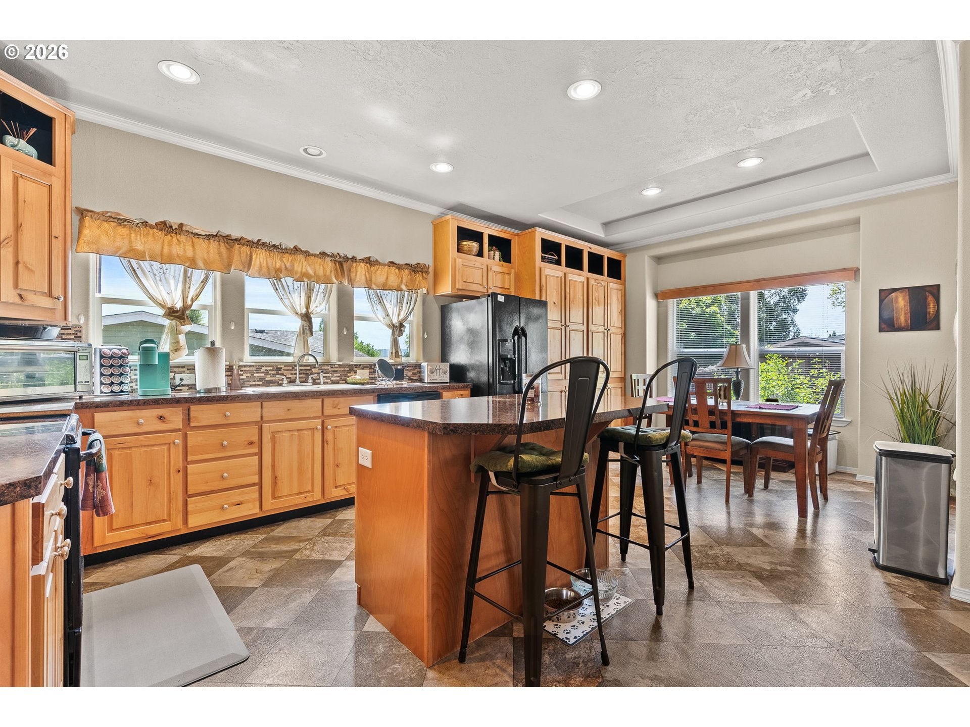 13620 Southwest Beef Bend Road, Unit 1 Portland, OR 97224 - Photo 13 of 34 a open kitchen with stainless steel appliances granite countertop a refrigerator a stove a dining table and chairs with wooden floor