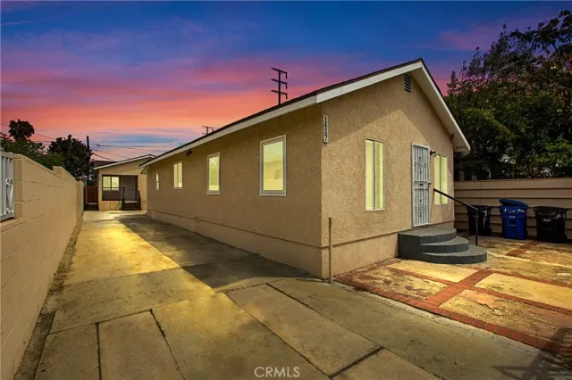 a view of a house with a small yard and wooden fence