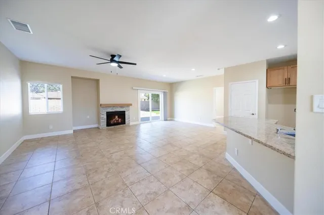 a view of an empty room with a fireplace and a window