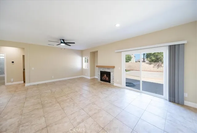 an empty room with windows and fireplace