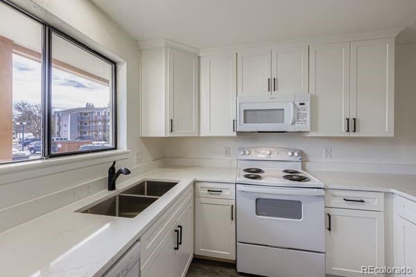 8678 Decatur Street, Unit 275 Westminster, CO 80031 - Photo 11 of 26 a kitchen with white cabinets and white appliances
