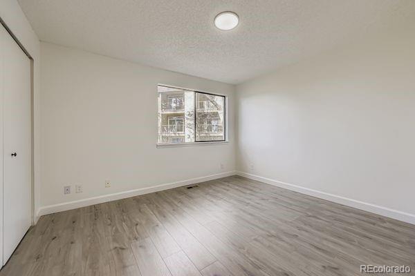 8678 Decatur Street, Unit 275 Westminster, CO 80031 - Photo 15 of 26 an empty room with wooden floor and windows