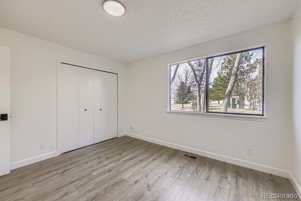 8678 Decatur Street, Unit 275 Westminster, CO 80031 - Photo 16 of 26 a view of an empty room with wooden floor and a window