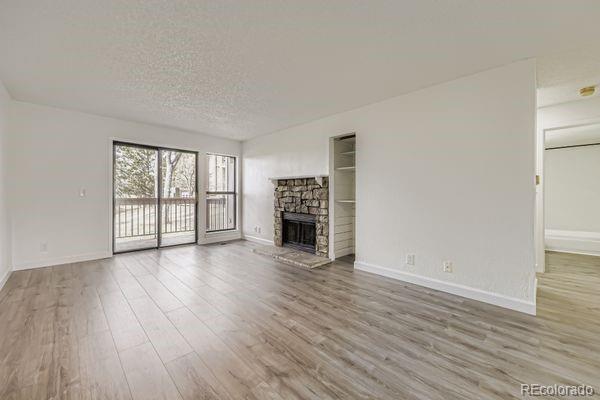 8678 Decatur Street, Unit 275 Westminster, CO 80031 - Photo 2 of 26 a view of a livingroom with wooden floor and a fireplace