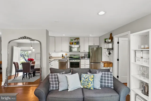 a living room with furniture and a dining table with kitchen view