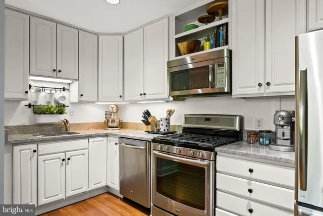 a kitchen with white cabinets and appliances