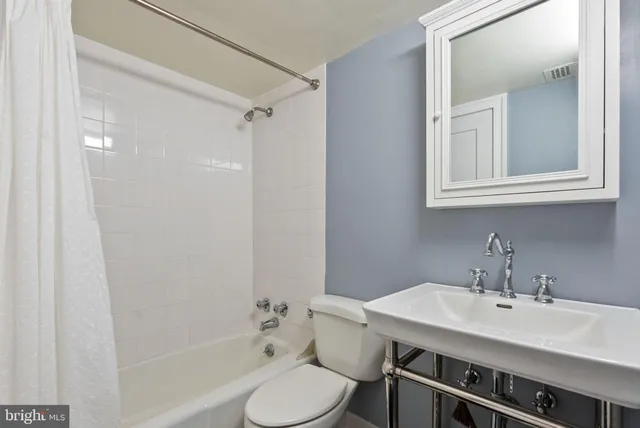 a bedroom with a bed and a flat tv screen on the dresser