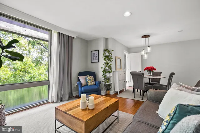 a living room with furniture a rug and a large window