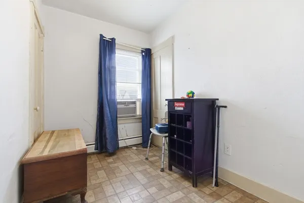 a bedroom with a bed chair and a large window