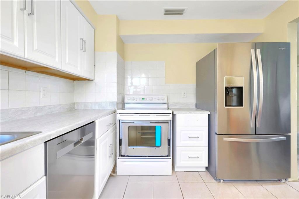 5306 Martin Street Naples, FL 34113 - Photo 36 of 48 a kitchen with a refrigerator sink and cabinets
