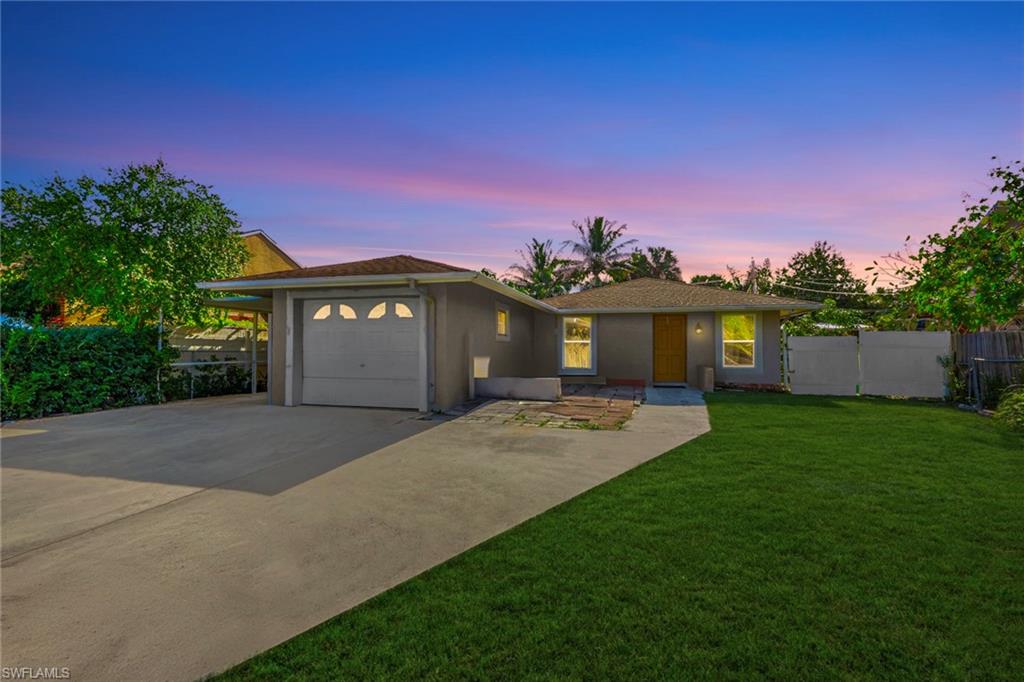 5306 Martin Street Naples, FL 34113 - Photo 10 of 48 a front view of a house with a garden and a tree