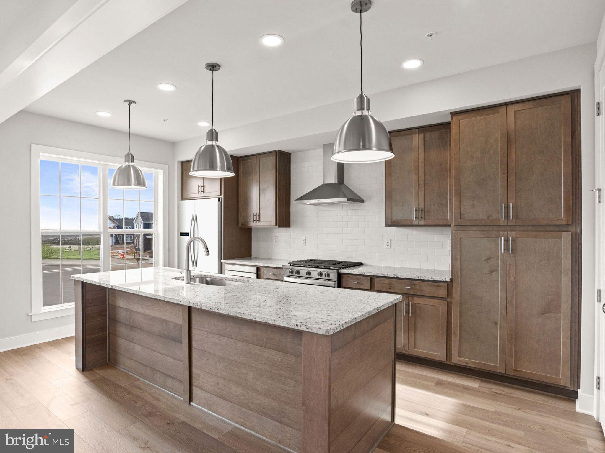 3 Sage Street Carlisle, PA 17015 - Photo 8 of 41 a kitchen with kitchen island granite countertop a sink a counter space appliances and cabinets