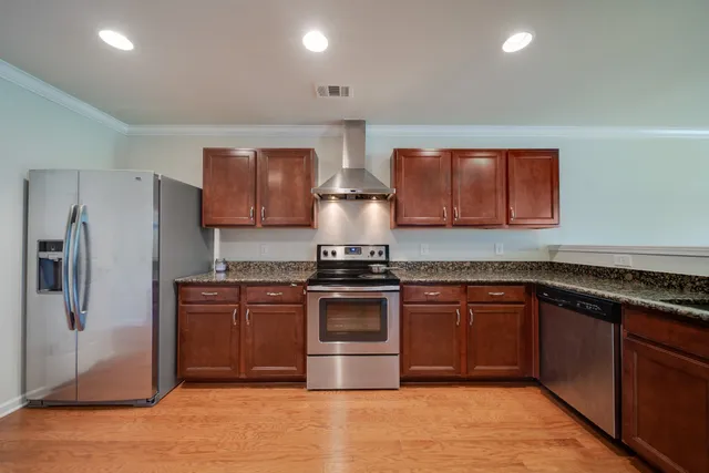 an empty room with wooden floor chandelier and windows