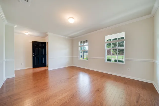 a view of an empty room with wooden floor and closet