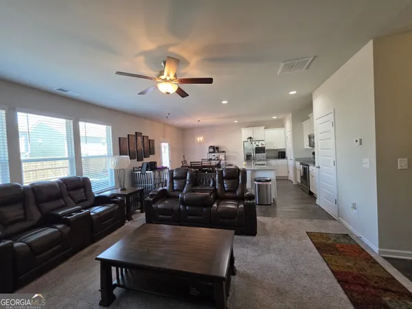 a living room with furniture ceiling fan and a rug