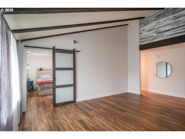 a view of empty room with wooden floor