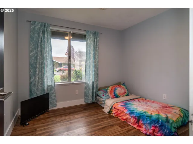 a bedroom with a bed and wooden floor
