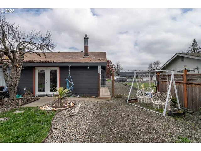 a view of a backyard with couches chair and wooden fence