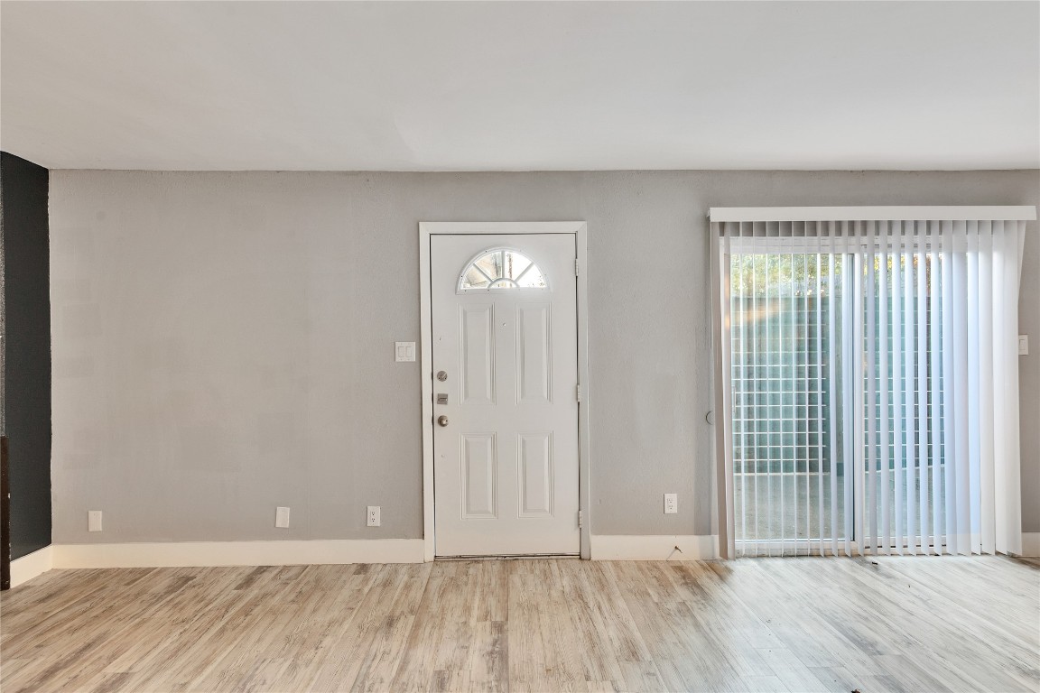 4721 Blueberry Trail, Unit A Austin, TX 78723 - Photo 11 of 23 a view of an empty room with wooden floor and a window