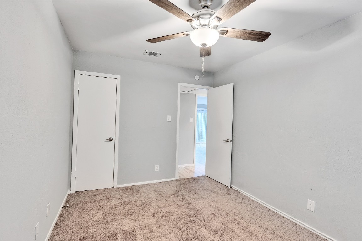 4721 Blueberry Trail, Unit A Austin, TX 78723 - Photo 16 of 23 an empty room with a chandelier fan and a ceiling fan
