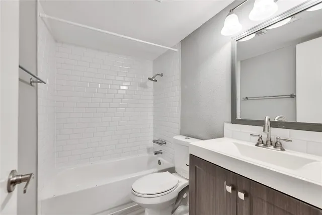 a bathroom with a bathtub shower sink mirror and toilet