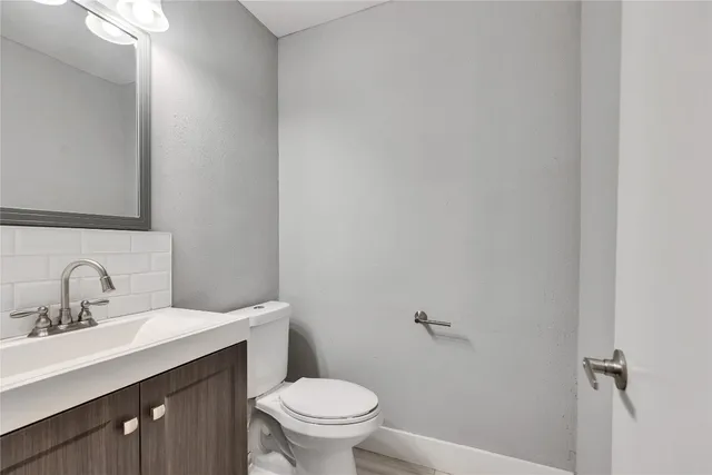 a bathroom with a sink mirror vanity and toilet