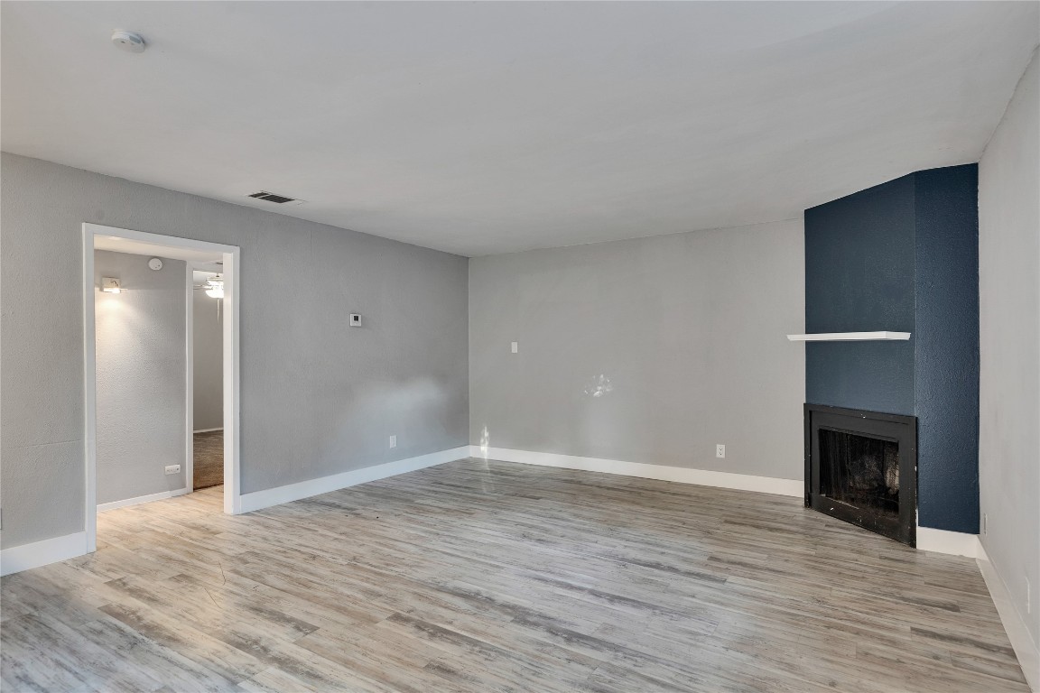 4721 Blueberry Trail, Unit A Austin, TX 78723 - Photo 4 of 23 a view of an empty room with wooden floor fireplace and a window
