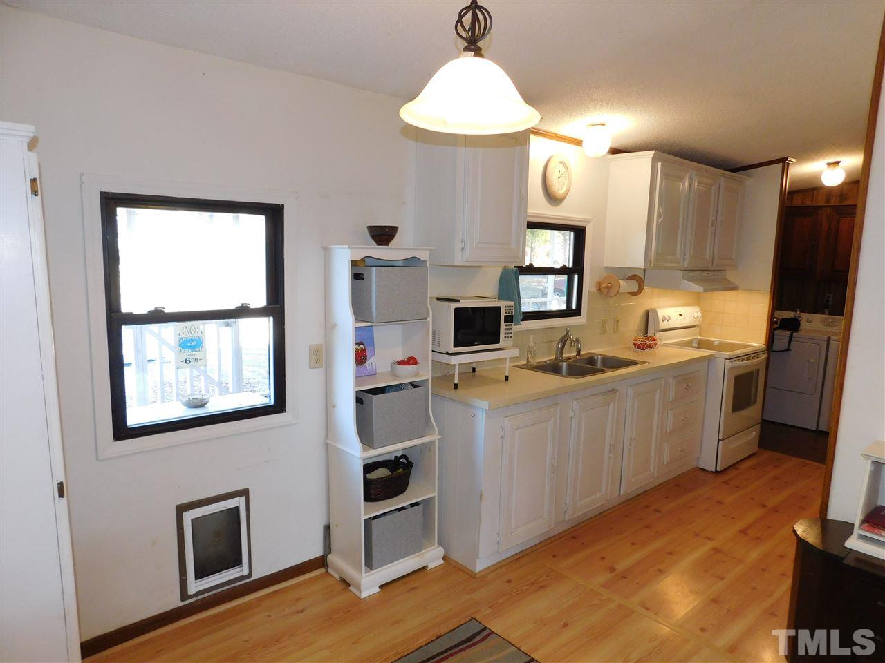 9402 Hampton Road Rougemont, NC 27572 - Photo 10 of 18 a kitchen with a sink wooden floor and black appliances