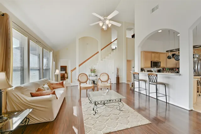 a living room with furniture kitchen view and a large window