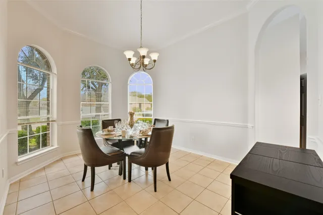 a view of a dining room with furniture a chandelier and a window