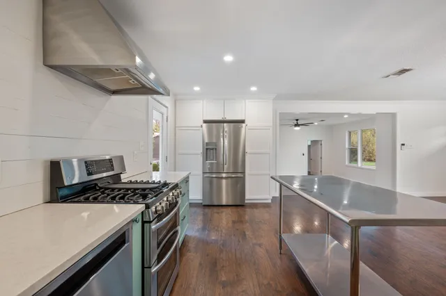 an empty room with wooden floor and a ceiling fan