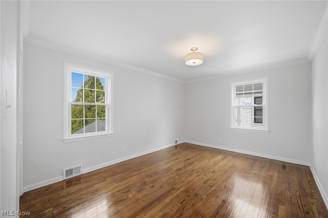 3722 Lindholm Road Shaker Heights, OH 44120 - Photo 21 of 34 Bright room featuring hardwood floors, two windows, crown molding, and a ceiling-mounted light fixture