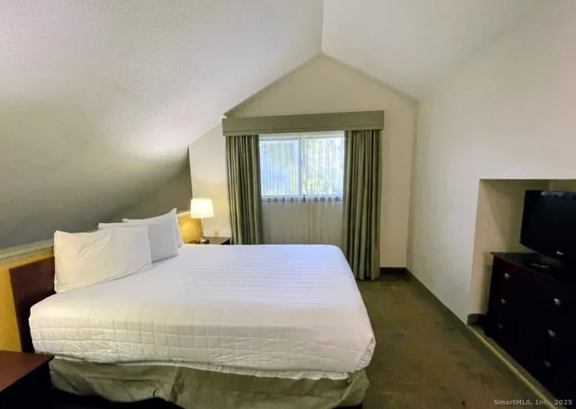 a bedroom with a bed and a flat screen tv