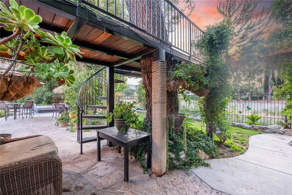25261 Avenida Rondel Valencia, CA 91355 - Photo 40 of 68 a view of a patio with table and chairs potted plants and a palm tree